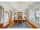 Elegant dining room with hardwood floors, bright windows, and decorative china cabinet at 1524 Guthrie Crossing Dr, Loganville, GA 30052