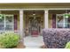 Inviting front porch with brick pillars, hanging plants, and a view of the landscaped yard at 1524 Guthrie Crossing Dr, Loganville, GA 30052