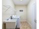 Functional laundry room with a utility sink, modern washer/dryer, storage cabinet, and overhead rack at 1524 Guthrie Crossing Dr, Loganville, GA 30052
