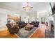 Well-lit living room with hardwood floors, fireplace, leather seating, and open flow to the kitchen at 1524 Guthrie Crossing Dr, Loganville, GA 30052