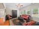 Bright living room showcasing hardwood floors, natural light, and a cozy sofa and chair set at 1524 Guthrie Crossing Dr, Loganville, GA 30052