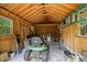 Interior view of a wooden shed with small windows and a green and yellow John Deere lawn mower at 1524 Guthrie Crossing Dr, Loganville, GA 30052