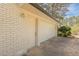 Exterior of garage featuring a white door and brick exterior, complemented by a well-maintained driveway at 1749 Lauranceae Way, Riverdale, GA 30296
