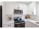 Bright kitchen with white cabinets, stainless steel appliances, and light countertops at 1749 Lauranceae Way, Riverdale, GA 30296