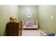 Bedroom featuring a wooden crib, dresser, muted green walls, and cozy atmosphere at 3402 Wynnewood Ln, Duluth, GA 30096