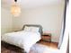 Bedroom with a bright window, wood floors and decorative light fixture at 3402 Wynnewood Ln, Duluth, GA 30096