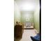 Bedroom featuring a wooden crib, dresser, muted green walls, and cozy atmosphere at 3402 Wynnewood Ln, Duluth, GA 30096
