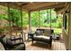Inviting screened porch with wicker seating, wood floors, and views of the lush backyard at 3402 Wynnewood Ln, Duluth, GA 30096
