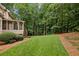 Lush backyard featuring manicured lawn, mature trees, and screened-in porch at 770 Spalding Heights Dr, Atlanta, GA 30350