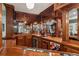 Luxurious custom-built home bar featuring dark wood, granite counters, shelving, and a wine cooler at 770 Spalding Heights Dr, Atlanta, GA 30350