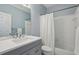 Modern bathroom with a vanity, white countertops, and a shower-tub combo with white tile at 770 Spalding Heights Dr, Atlanta, GA 30350