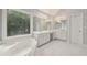 Large bathroom with dual sinks, a soaking tub, a decorative window, and white cabinets at 770 Spalding Heights Dr, Atlanta, GA 30350