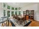 Elegant dining room featuring large windows, hardwood floors, a dark area rug, and classic wood furniture at 770 Spalding Heights Dr, Atlanta, GA 30350