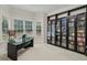 Bright home office with a modern glass desk, natural light, and custom built-in shelving for storage at 770 Spalding Heights Dr, Atlanta, GA 30350