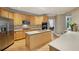 Well-appointed kitchen with light wood cabinets, stainless steel appliances, a center island, and hardwood floors at 770 Spalding Heights Dr, Atlanta, GA 30350