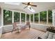 Relaxing screened-in porch featuring wood flooring, skylights, and wooded backyard views at 770 Spalding Heights Dr, Atlanta, GA 30350