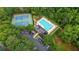 Overhead view of community pool and tennis courts surrounded by greenery at 140 Ashewoode Downs Ln, Johns Creek, GA 30005