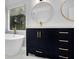 Modern bathroom featuring a dark vanity with marble top, gold accents and a soaking tub at 140 Ashewoode Downs Ln, Johns Creek, GA 30005