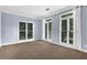Bright bedroom with large windows, neutral walls, and plush carpet flooring at 140 Ashewoode Downs Ln, Johns Creek, GA 30005
