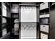 Custom-built walk-in closet with dark wood organizers, hanging rods and storage at 140 Ashewoode Downs Ln, Johns Creek, GA 30005