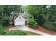 Two-story home featuring a two car garage and landscaped front yard at 140 Ashewoode Downs Ln, Johns Creek, GA 30005