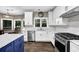 Bright kitchen featuring stainless steel appliances, white cabinets, and a blue kitchen island at 140 Ashewoode Downs Ln, Johns Creek, GA 30005