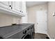 Modern laundry room with large washer and dryer at 140 Ashewoode Downs Ln, Johns Creek, GA 30005