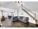 Bright open-concept living room featuring hardwood floors and staircase near the white kitchen with a blue island at 140 Ashewoode Downs Ln, Johns Creek, GA 30005
