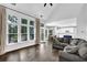 Open-concept living area with large windows, hardwood floors, and a seamless transition to the kitchen at 140 Ashewoode Downs Ln, Johns Creek, GA 30005
