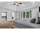 Comfortable bedroom featuring a tray ceiling, large window, and closet with an ensuite bathroom at 140 Ashewoode Downs Ln, Johns Creek, GA 30005