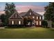 Beautiful brick home with lush landscaping, a well-manicured lawn, and classic architectural details at 390 Wilde Green Dr, Roswell, GA 30075