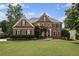 Beautiful brick two-story home featuring manicured lawn and mature trees at 390 Wilde Green Dr, Roswell, GA 30075