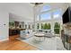 Open-concept living room with stone fireplace, views of the kitchen, and large windows at 390 Wilde Green Dr, Roswell, GA 30075
