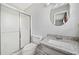 Well-lit bathroom featuring a shower with glass doors, vanity with granite countertop, and a round mirror at 58 6Th W Ave, Dallas, GA 30157