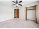 Comfortable bedroom featuring carpeted floors, a ceiling fan, closet with wood doors and view to the hallway at 58 6Th W Ave, Dallas, GA 30157