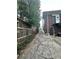 View of the cracked asphalt backyard featuring a side view of the building with foliage along the fence line at 472 Parkway Ne Dr, Atlanta, GA 30308