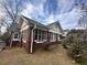 Charming brick home with screened porch, white trim, mature trees, and a well-maintained lawn at 472 Parkway Ne Dr, Atlanta, GA 30308