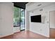 Living room features hardwood floors, a window, modern lighting, and a flatscreen TV mounted on the wall at 855 Peachtree Ne St # 1108, Atlanta, GA 30308
