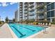 Outdoor pool with lounge chairs and a view of the building's exterior and landscaping at 855 Peachtree Ne St # 1108, Atlanta, GA 30308