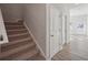 Hallway features carpeted stairs, hardwood floors, white trim, and two closet doors at 11857 Rizvan Pl, Covington, GA 30014
