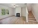 Bright living room features hardwood floors, a black fireplace, a window, and stairs at 11857 Rizvan Pl, Covington, GA 30014