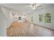 Bright, open-concept living room with wood floors connects to a modern kitchen with white cabinets at 11857 Rizvan Pl, Covington, GA 30014