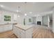 Bright, open-concept living space with wood floors, a fireplace, and a kitchen island at 11857 Rizvan Pl, Covington, GA 30014