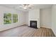 Bright living room features hardwood floors, a black fireplace, and a window at 11857 Rizvan Pl, Covington, GA 30014