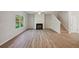 Spacious living room features hardwood floors, a black fireplace, a window, and stairs at 11857 Rizvan Pl, Covington, GA 30014