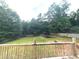 A view of the vast backyard with mature trees, framed by a wooden fence for added privacy at 350 Glynnshire Ct, Covington, GA 30016