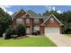 Traditional red brick two-story home with an attached two car garage and manicured front lawn at 350 Glynnshire Ct, Covington, GA 30016