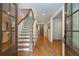 Bright foyer featuring hardwood floors, staircase with white risers, and glass-paned doors offering abundant natural light at 505 Junction Pt, Roswell, GA 30075