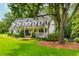 Beautiful exterior view of the house with a well-maintained lawn, a mature shade tree, and a welcoming front porch at 505 Junction Pt, Roswell, GA 30075