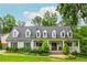 Charming home featuring a welcoming front porch, dormer windows, manicured lawn, and mature landscaping, creating inviting curb appeal at 505 Junction Pt, Roswell, GA 30075